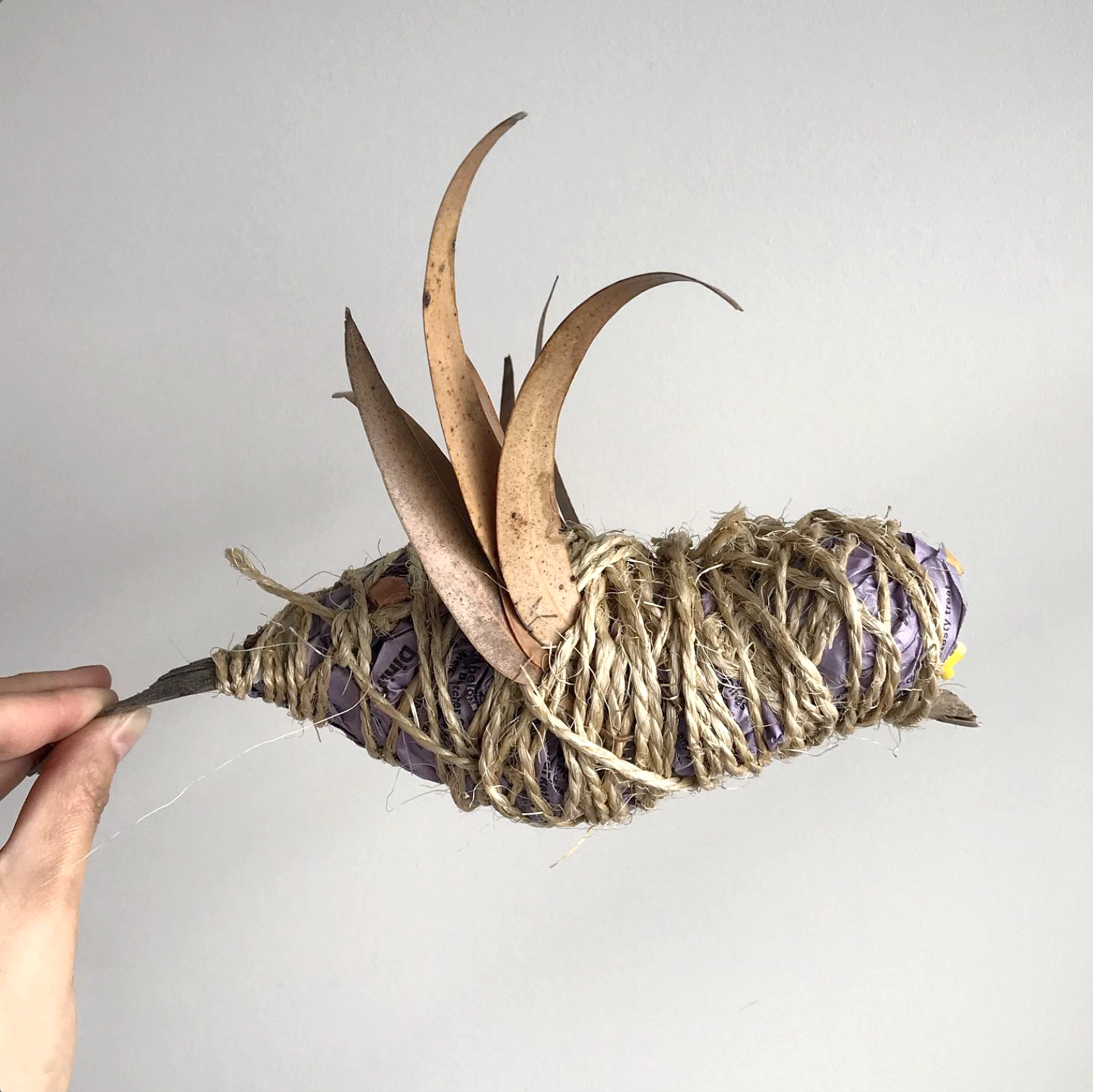Handmade woven bird crafted from natural fibres, paper and dried leaves